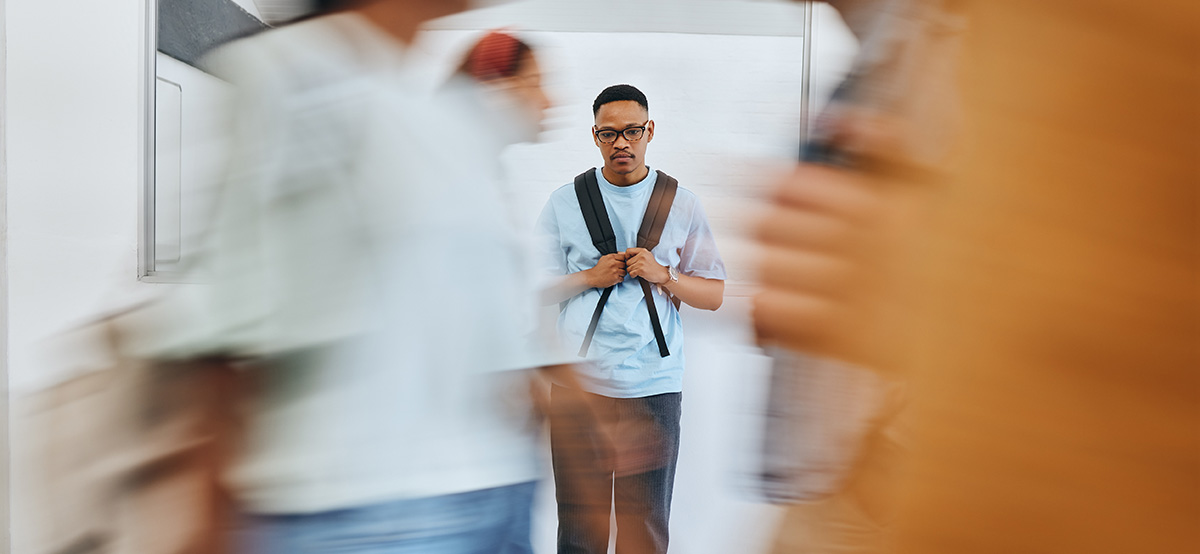 Depressed student stands alone after dealing with academic harassment.